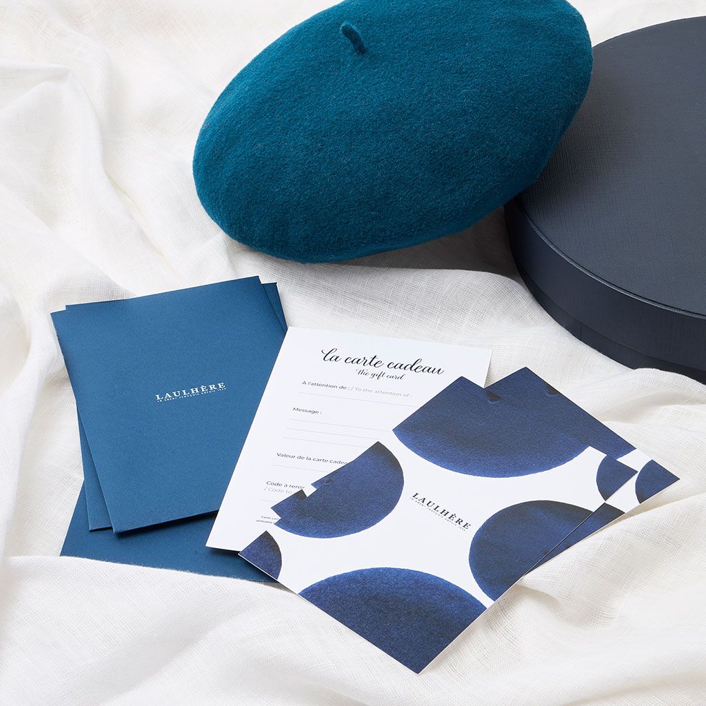 A person discovering a Laulhère gift card and its blue envelope